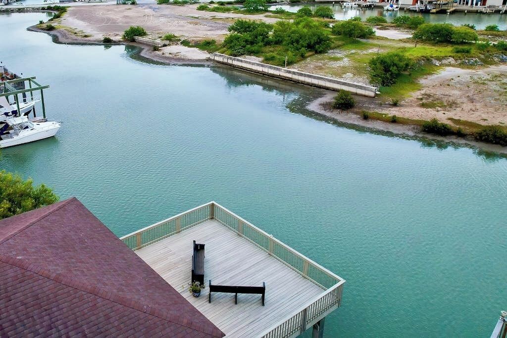 A waterfront property with a dock, a wooden deck, and a view of the water.