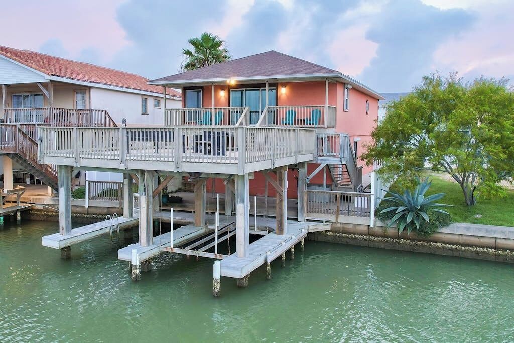 A waterfront property with a multi-level dock and a house with a balcony.