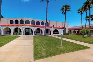 A building with an arched entrance, labeled 'Activity Center,' and a sign indicating 'Laundry' to the right. - Long Island Village 790 W Oyster Drive Bungalow (Port Isabel)