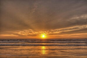 Un atardecer sobre una playa con olas.