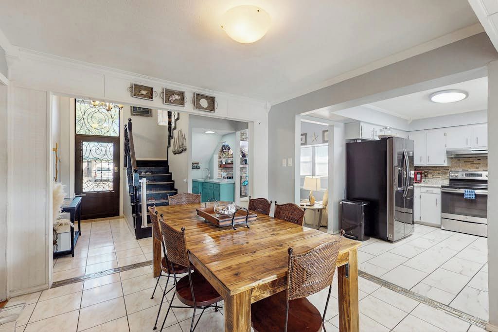 Una cocina amplia con comedor, una escalera y vista al área de estar.