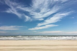 Ein Strand mit blauem Himmel und Meereswellen.