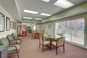 A waiting area with chairs, a round table, and a fire extinguisher. - Beach Club - Casa Del Sol (Corpus Christi)
