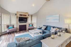 Ein Wohnzimmer mit Kamin, Fernseher und einer Couch.