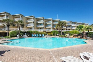 Hotel amb piscina, diversos balcons i palmeres.
