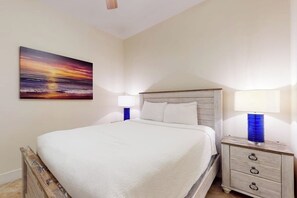 Ein Schlafzimmer mit einem Bett, Nachttischen und einem an der Wand hängenden Bild.