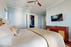 A bedroom with a bed, a ceiling fan, a television, and a dresser. - Blue Claws - Bayfront, Elevator & Resort Pools (Galveston)