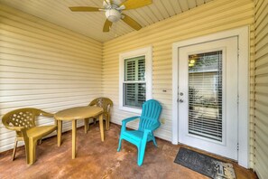A covered porch with a ceiling fan, a table, chairs, and a door with a window. - Palm Bay 504 - Heated Pool & Dog-Friendly (Corpus Christi)