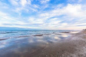 A beach with wet sand and gentle waves, under a partly cloudy sky. - Aztec Habitat No 19 - Pool, 1 Minute to the Beach (South Padre Island)