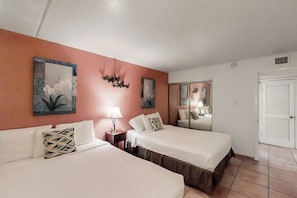 A hotel room with two beds, a nightstand, a lamp, and a mirror. - Gulfview I #207 - Bay Views, Pool, Walk to Beach (South Padre Island)