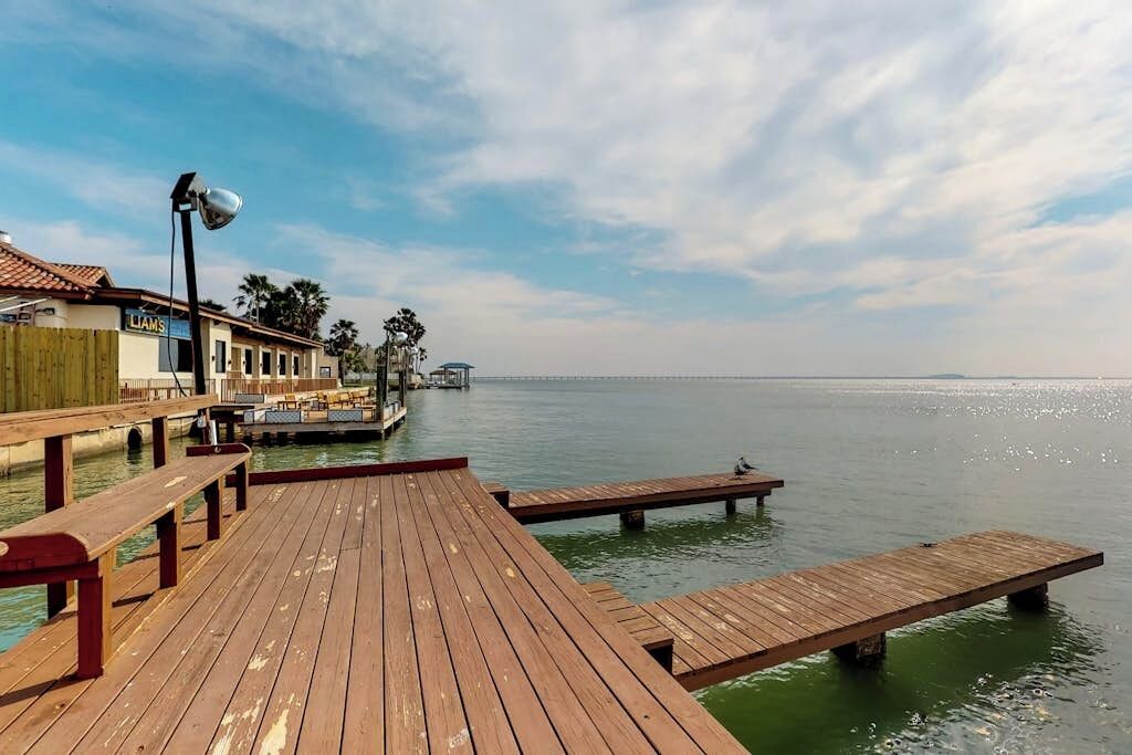 A wooden pier extending into calm water, with a building labeled 'LAMS' on the left.