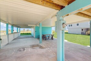 A covered outdoor area with a picnic table and a concrete floor. - Seaside Escape - Ocean View, Yard, Steps to Sand (Galveston)
