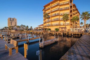 A waterfront hotel with multiple balconies, a dock area, and palm trees. - Galleon Bay Condominiums #207 (South Padre Island)