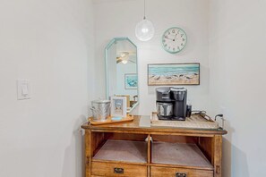 A wooden desk with a coffee maker, a framed picture, and a clock on the wall. - Puente Vista - Aloha, Sunset on the Bay (Corpus Christi)