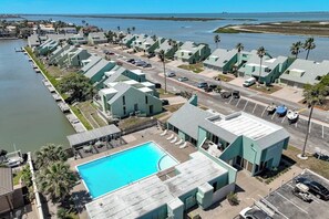Un hotel a la costa amb diversos edificis, una piscina i un port esportiu.