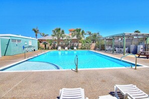 A swimming pool with lounge chairs and a covered seating area. - Puente Vista 119 - Waterfront, Bay Views & Pool (Corpus Christi)
