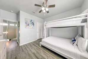 A room with a bunk bed, a ceiling fan, a door, and a painting on the wall. - Nemo Cay - Mermaids Splash (Corpus Christi)