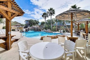 Un espace piscine équipé d’un jacuzzi, de chaises longues et de parasols.