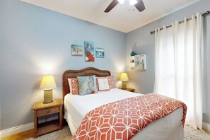 A bedroom with a bed, two bedside tables with lamps, a ceiling fan, and wall art. - Fish Tail - Covered Patio & Yard, Near Beach (Rockport)