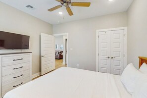 A bedroom with a bed, a dresser, a ceiling fan, and a television. - Kamp ENJoY #157 - Pool, Fishing Pond & Dogs OK (Rockport)