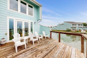 A wooden deck with white chairs and a view of a water body. - Pelican Point - Waterfront, Pool & Dock Access (Rockport)