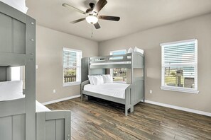 A room with a bunk bed, a ceiling fan, and large windows. - Blue Pelican - Bayfront, Fenced Yard & Balconies (Corpus Christi)