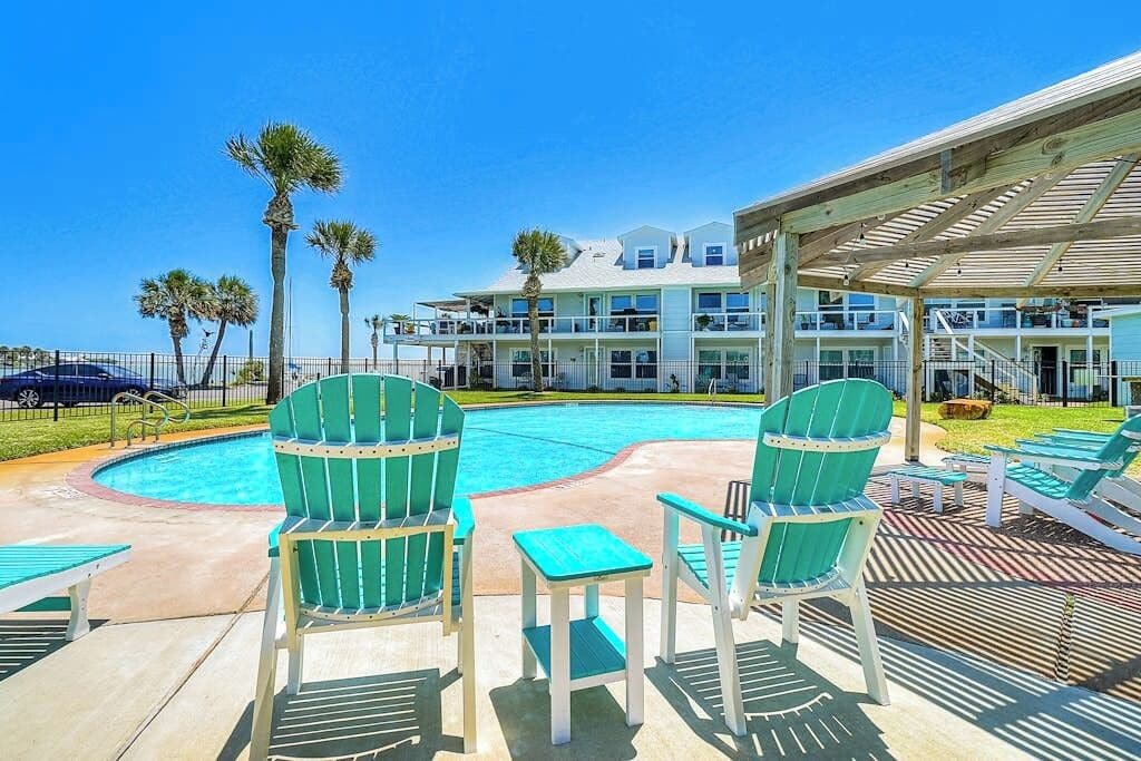A pool area with chairs and a covered seating area.