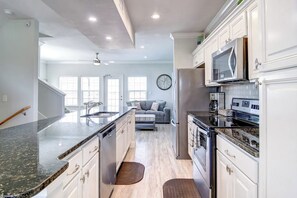 A modern kitchen with granite countertops, stainless steel appliances, and a built-in oven. - Pathway to the Sea 14838 (Corpus Christi)