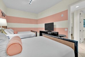 A hotel room with two beds, a television, and a desk. - Sapphire Condominiums #408 (South Padre Island)