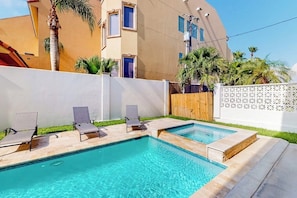 Ein Swimmingpool mit zwei Liegestühlen und einer Holzterrasse.