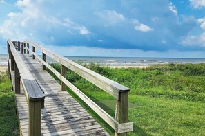Ein Holzsteg führt zu einem Strand, an dem ein Schild mit der Aufschrift 'Private Property' steht.