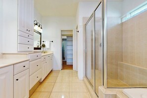 Ein modernes Badezimmer mit Dusche, Waschtisch mit Schubladen und Spiegel.