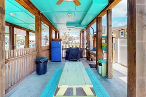 A covered outdoor area with a picnic table, a barbecue grill, and a trash bin. - Down By The Sea - Private Pool, Downtown Port A (Port Aransas)