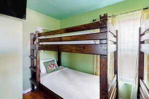 A bunk bed with a wooden frame and a single mattress. - Down By The Sea - Private Pool, Downtown Port A (Port Aransas)