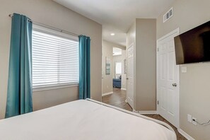 A bedroom with a bed, a television, and a window with curtains. - Leeward Isles 207 - Pool, Walk to the Water (Corpus Christi)