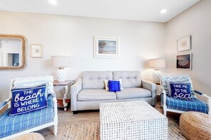 A living room with a sofa, two armchairs, a coffee table, and a painting on the wall. - Beach Club 173 - Pool, Sauna & Beach Access (Corpus Christi)