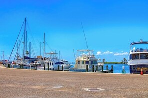 A marina with several boats docked, a clear blue sky, and a calm water body. - Fulton Bliss - Boat Parking, Porch & Dogs OK (Rockport)