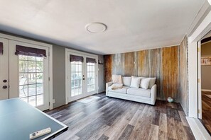 Ein Zimmer mit einem großen Fenster, einem Sofa und einem Tischtennis-Tisch.