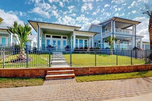 A beachfront property with a covered patio, a pool, and a fenced lawn. - Reserve Lane Retreat | Reserve at St Charles Bay (Rockport)