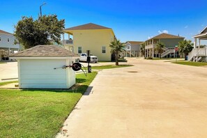 A residential street with houses, a small shed, and a stop sign. - Coral Reef Gataway - Pool, Playground & Bay Views (Rockport)