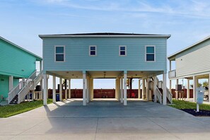 A two-story building with a covered patio area, a staircase, and a fenced yard. - Coral Reef Gataway - Pool, Playground & Bay Views (Rockport)