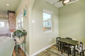 A dining area with a table and chairs, a potted plant, and a stone accent wall. - The Prescription - Waterfront Dock, Sleeps 12 (Rockport)
