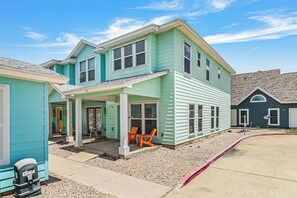 A two-story house with a covered porch and outdoor seating. - CopaCabana - Pool & Patio, Near the Beach (Port Aransas)
