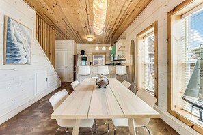 Un intérieur en bois comprenant une table à manger, des chaises et un coin cuisine.
