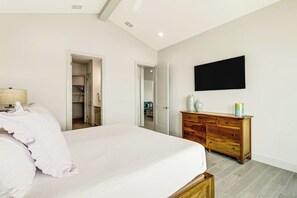 A bedroom with a bed, a dresser, a television, and a closet. - Casa Bahia San Carlos (Rockport)