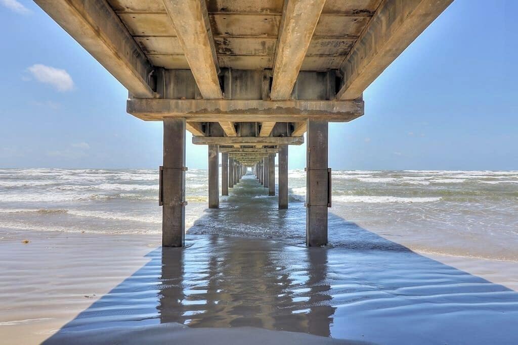 En mole, der strækker sig ud i havet under en klar himmel.
