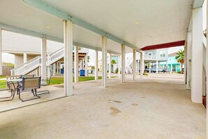Ein überdachter Außenbereich mit Betonboden, einer Treppe und einem Picknicktisch.