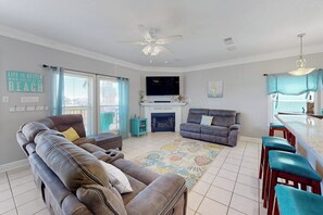 A living room with a sofa, a television, and a fireplace. - Smiles in Isla Del Sol (Galveston)
