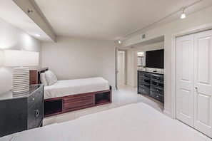 A bedroom with a bed, bedside table, dresser, and wardrobe. - Solare Tower 1202 - Gulf Views & Beach Access (South Padre Island)
