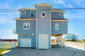 Ein zweistöckiges Wohnhaus mit Garage, überdachter Veranda und einem eingezäunten Garten.
